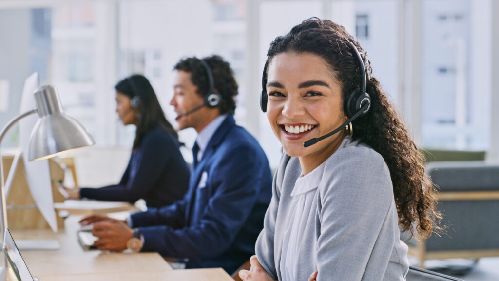 Call center woman, smile and portrait at headphones, job and staff group with computer, advice and office. Telemarketing agent, pc and microphone at help desk, consulting or listen for tech support